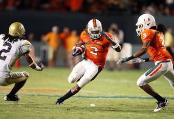 FORT LAUDERDALE, FL - SEPTEMBER 17:  Running back Graig Cooper #2 of the Miami Hurricanes looks to avoid being brought down by cornerback Mario Butler #2 of the Georgia Tech Yellow Jackets at Land Shark Stadium on September 17, 2009 in Fort Lauderdale, Florida. Miami defeated Georgia Tech 33-17.  (Photo by Doug Benc/Getty Images)