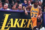 31 Jan 1996: Earvin Magic Johnson #32 of the Los Angeles Lakers kneels on the sidelines in his return to the NBA during the game against the Golden State Warriors at the Great Western Forum in Inglewood, California.