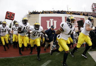 BLOOMINGTON, IN - NOVEMBER 11:  Darnell Hood #4 of the Michigan Wolverines leads the team onto the field in front of head coach Lloyd Carr for a game against the Indiana Hoosiers on November 11, 2006 at Memorial Stadium in Bloomington, Indiana. Michigan won the game 34-3.  (Photo by Gregory Shamus/Getty Images)