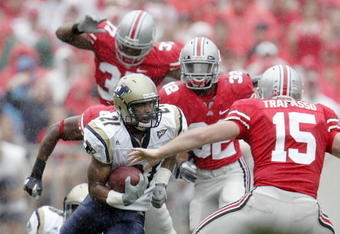 COLUMBUS - SEPTEMBER 8:  Andre Jones #21 of the Akron Zips carries the ball as he is chased by Thaddeus Gibson #37, Eugene Clifford #32 and A.J. Trapasso #15 of the Ohio State Buckeyes during the first half on September 8, 2007 at Ohio Stadium in Columbus, Ohio.  (Photo by David Maxwell/Getty Images)