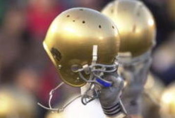 SOUTH BEND, IN - NOVEMBER 23: Members of the Notre Dame football team hold up their helmets to the student section after a game against Rutgers on November 23, 2002 at Notre Dame Stadium in South Bend, Indiana. Notre Dame defeated Rutgers 42-0. (Photo by Jonathan Daniel/Getty Images)