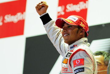 SINGAPORE - SEPTEMBER 27:  Lewis Hamilton of Great Britain and McLaren Mercedes celebrates on the podium after winning the Singapore Formula One Grand Prix at the Marina Bay Street Circuit on September 27, 2009 in Singapore.  (Photo by Clive Mason/Getty Images)
