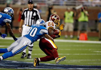 DETROIT, MI - SEPTEMBER 27: Running back Clinton Portis #26 of the Washington Redskins runs with the football as he is tackled by defensive back Ko Simpson #30 of the Detroit Lions at Ford Field on September 27, 2009 in Detroit, Michigan. The Lions defeated the Redskins 19-14. (Photo by Scott Boehm/Getty Images)