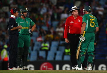 CENTURION, SOUTH AFRICA - SEPTEMBER 27:  Andrew Strauss of England and Albie Morkel (L) look on as Graham Smith discusses the use of a runner with umpire Steve Davis, during The ICC Champions Trophy match between South Africa and England played at Supersport Park on September 27, 2009 in Centurion, South Africa.  (Photo by Julian Herbert/Getty Images)