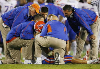 LEXINGTON, KY - SEPTEMBER 26: Quarterback Tim Tebow #15 of the Florida Gators is tended to by head coach Urban Meyer (R) and staff after Tebow was sacked by Taylor Wyndham #94 of the Kentucky Wildcats during the third quarter of the game at Commonwealth Stadium on September 26, 2009 in Lexington, Kentucky. (Photo by Andy Lyons/Getty Images)