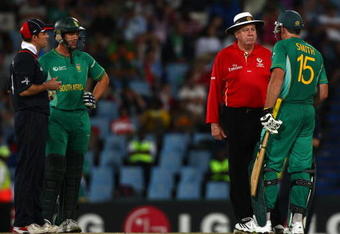 CENTURION, SOUTH AFRICA - SEPTEMBER 27:  Andrew Strauss of England and Albie Morkel (L) look on as Graham Smith discusses the use of a runner with umpire Steve Davis, during The ICC Champions Trophy match between South Africa and England played at Supersport Park on September 27, 2009 in Centurion, South Africa.  (Photo by Julian Herbert/Getty Images)