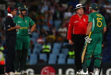 CENTURION, SOUTH AFRICA - SEPTEMBER 27:  Andrew Strauss of England and Albie Morkel (L) look on as Graham Smith discusses the use of a runner with umpire Steve Davis, during The ICC Champions Trophy match between South Africa and England played at Supersport Park on September 27, 2009 in Centurion, South Africa.  (Photo by Julian Herbert/Getty Images)