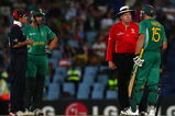 CENTURION, SOUTH AFRICA - SEPTEMBER 27:  Andrew Strauss of England and Albie Morkel (L) look on as Graham Smith discusses the use of a runner with umpire Steve Davis, during The ICC Champions Trophy match between South Africa and England played at Supersport Park on September 27, 2009 in Centurion, South Africa.  (Photo by Julian Herbert/Getty Images)