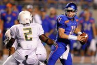 BOISE, ID - SEPTEMBER 3:  Kellen Moore #11 of the Boise State throws a pass under pressure by T.J. Ward #2 of the Oregon Ducks in second quarter of the game on September 3, 2009 at Broncos Stadium in Boise, Idaho. Boise State won the game 19-8. (Photo by Steve Dykes/Getty Images)