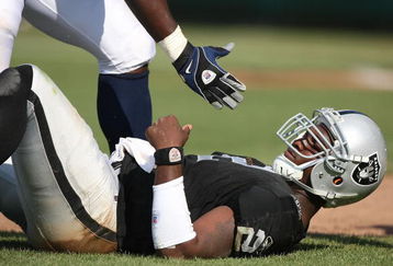 OAKLAND, CA - SEPTEMBER 27:  JaMarcus Russell #2 of the Oakland Raiders is helped up after getting hit against the Denver Broncos on September 27, 2009 during an NFL game at the Oakland-Alameda County Coliseum in Oakland, California.  (Photo by Jed Jacobsohn/Getty Images)