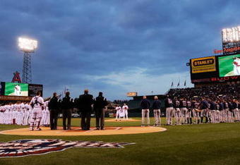 ANAHEIM, CA - APRIL 10:  Los Angeles Angels and Boston Red Sox teams line up as Torii Hunter #48 (L) and  pitcher John Lackey #41 (R) of the Los Angeles Angels hold teammate Nick Adenhart's jersey during a moment of silence before the start of the game against Boston Red Sox at Angel Stadium April 10, 2009 in Anaheim, California. Adenhart and two others were killed in car crash on April 9.  (Photo by Kevork Djansezian/Getty Images)