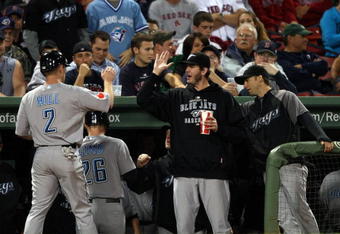 BOSTON - SEPTEMBER 29:  Aaron Hill #2 and Adam Lind #26 of the Toronto Blue Jays are congratulated by teammates after Lind hit a two run homer in the first inning against the Boston Red Sox on September 29, 2009 at Fenway Park in Boston, Massachusetts.  (Photo by Elsa/Getty Images)