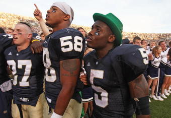 SOUTH BEND, IN - SETPEMBER 19: (L-R) Mike Anello #37, Brian Smith #58 and Armando Allen, Jr. #5, (wearing the hat of the leprechaun mascot) of the Notre Dame Fighting Irish sing with students after a win over the Michigan State Spartans on September 19, 2009 at Notre Dame Stadium in South Bend, Indiana. Notre Dame defeated Michigan State 33-30. (Photo by Jonathan Daniel/Getty Images)