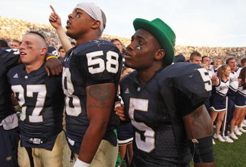 SOUTH BEND, IN - SETPEMBER 19: (L-R) Mike Anello #37, Brian Smith #58 and Armando Allen, Jr. #5, (wearing the hat of the leprechaun mascot) of the Notre Dame Fighting Irish sing with students after a win over the Michigan State Spartans on September 19, 2009 at Notre Dame Stadium in South Bend, Indiana. Notre Dame defeated Michigan State 33-30. (Photo by Jonathan Daniel/Getty Images)