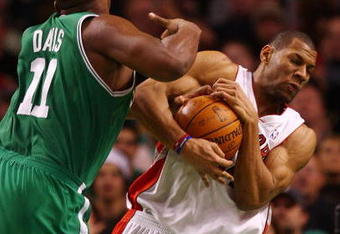 BOSTON - DECEMBER 07:  Joey Graham #14 of the Toronto Raptors grabs the ball from Glen Davis #11 of the Boston Celtics on December 7, 2007 at the TD Banknorth Garden in Boston, Massachusetts. NOTE TO USER: User expressly acknowledges and agrees that, by downloading and or using this Photograph, user is consenting to the terms and conditions of the Getty Images License Agreement.  (Photo by Elsa/Getty Images)