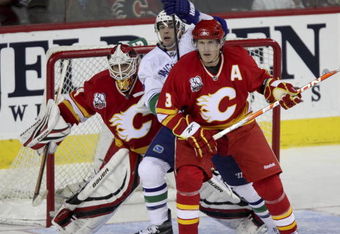 CALGARY, AB -OCTOBER 1: Vancouver Canucks Alexandre Burrows #14 gets wedged between Dion Phaneuf #3 and goaltender Miikka Kiprusoff #34 of the Calgary Flames in the third period of NHL action during the season opener on October 1, 2009 at the Pengrowth Saddledome in Calgary, Alberta, Canada. (Photo by Mike Ridewood/Getty Images)