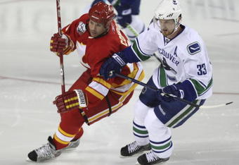 CALGARY, AB - OCTOBER 1:  Craig Conroy #24 of the Calgary Flames tries to get around Henrik Sedin #33 of the Vancouver Canucks in the second period of NHL action during the season opener on October 1, 2009 at the Pengrowth Saddledome in Calgary, Alberta, Canada. (Photo by Mike Ridewood/Getty Images)