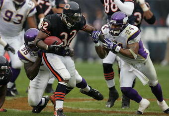 CHICAGO - OCTOBER 14: Cedric Benson #32 of the Chicago Bears breaks away from Kenechi Udeze #95 and Dwight Smith #24 of the Minnesota Vikings on October 14, 2007 at Soldier Field in Chicago, Illinois. The Vikings defeated the Bears 34-31. (Photo by Jonathan Daniel/Getty Images)