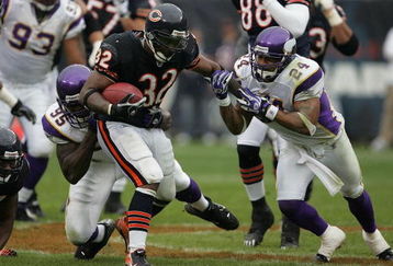CHICAGO - OCTOBER 14: Cedric Benson #32 of the Chicago Bears breaks away from Kenechi Udeze #95 and Dwight Smith #24 of the Minnesota Vikings on October 14, 2007 at Soldier Field in Chicago, Illinois. The Vikings defeated the Bears 34-31. (Photo by Jonathan Daniel/Getty Images)