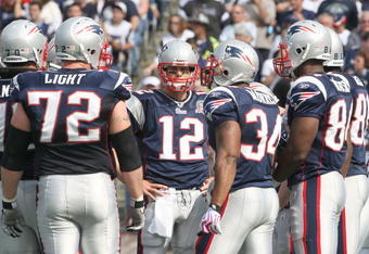 FOXBORO, MA - OCTOBER 4:  Tom Brady #12 of the New England Patriots stands in a huddle during a game against the Baltimore Ravens at Gillette Stadium on October 4, 2009 in Foxboro, Massachusetts. (Photo by Jim Rogash/Getty Images)