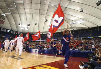MINNEAPOLIS - MARCH 22:  Cheerleaders for the Dayton Flyers runs by players from the Kansas Jayhawks during warm ups for their second round of the NCAA Division I Men's Basketball Tournament at the Hubert H. Humphrey Metrodome on March 22, 2009 in Minneapolis, Minnesota.  (Photo by Jonathan Daniel/Getty Images)