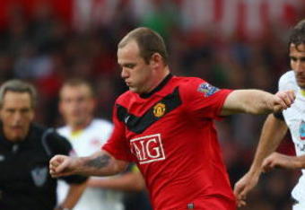 MANCHESTER, ENGLAND - OCTOBER 03:  Wayne Rooney of Manchester United goes past Lorik Cana of Sunderland during the Barclays Premier League match between Manchester United and Sunderland at Old Trafford on October 3, 2009 in Manchester, England. (Photo by Clive Brunskill/Getty Images)