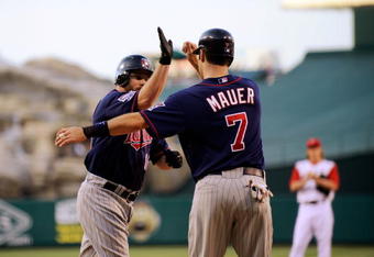 ANAHEIM, CA - JULY 23:  Jason Kubel #16 of the Minnesotta Twins is congratulated by teammate Joe Maur #7 after hitting a two-run home run off pitcher Jered Weaver #36 of the Los Angeles Angels of Anaheim during the first inning of the baseball game on July 23, 2009 in Anaheim, California.  mauer scored on the home run.  (Photo by Kevork Djansezian/Getty Images)