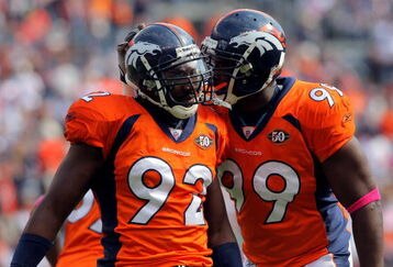 DENVER - OCTOBER 04:  Elivs Dumervil #92 of the Denver Broncos celebrates with Vonnie Holliday #99 as they defend against the Dallas Cowboys during NFL action at Invesco Field at Mile High on October 4, 2009 in Denver, Colorado. The Broncos defeated the Cowboys 17-10.  (Photo by Doug Pensinger/Getty Images)