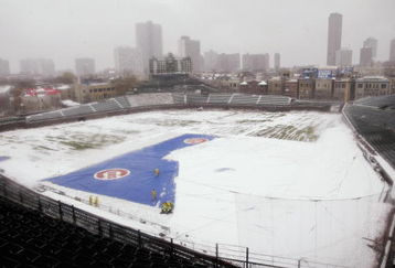 CHICAGO, IL - APRIL 7:  Workmen from the Wrigley Field grounds crew shovel snow from the infield of the park in Chicago, Illinois April 7, 2003. The Chicago Cubs were to play their home opener against the Montreal Expos today but the game was cancelled due to the snow. (Photo by Scott Olson/Getty Images)