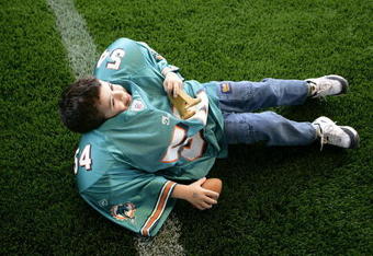 MIAMI - JANUARY 27:  Carlos Rios, 4-years-old, from Miami tries on a set of shoulder pads during the NFL Experience at Miami Dolphin Stadium on January 27, 2007 in Miami, Florida.  (Photo by Eliot J. Schechter/Getty Images)