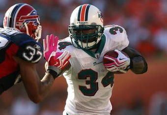MIAMI - OCTOBER 04:  Running back Ricky Williams #34 of the Miami Dolphins stiff-arms George Wilson #37 of the Buffalo Bills at Land Shark Stadium on October 4, 2009 in Miami, Florida. The Dolphins defeated the Bills 38-10.  (Photo by Doug Benc/Getty Images)