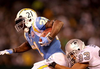 OAKLAND, CA - SEPTEMBER 14:  LaDainian Tomlinson #21 of the San Diego Chargers is tackled by Tyvon Branch #33 of the Oakland Raiders during their game on September 14, 2009 at the Oakland-Alameda County Coliseum in Oakland, California.  (Photo by Ezra Shaw/Getty Images)