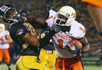 COLUMBIA, MO - OCTOBER 11:  Dez Bryant #1 of the Oklahoma State Cowboys stiff-arms Castine Bridges #21 of the Missouri Tigers  on October 11, 2008 at Memorial Stadium in Columbia, Missouri.  (Photo by G. Newman Lowrance/Getty Images)