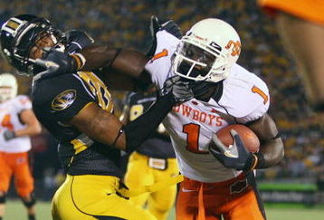 COLUMBIA, MO - OCTOBER 11:  Dez Bryant #1 of the Oklahoma State Cowboys stiff-arms Castine Bridges #21 of the Missouri Tigers  on October 11, 2008 at Memorial Stadium in Columbia, Missouri.  (Photo by G. Newman Lowrance/Getty Images)