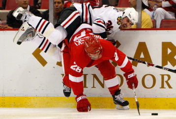 DETROIT - MAY 27:  Dave Bolland #36 of the Chicago Blackhawks falls over the top of Brian Rafalski #28 the Detroit Red Wings as Rafalski controls the puck during Game Five of the Western Conference Championship Round of the 2009 Stanley Cup Playoffs on May 27, 2009 at Joe Louis Arena in Detroit, Michigan.  (Photo by Gregory Shamus/Getty Images)