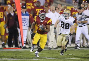 LOS ANGELES - NOVEMBER 29:  Stafon Johnson #13 of the USC Trojans carries the ball against Kyle McCarthy #28 of the Notre Dame Fighting Irish on November 29, 2008 at the Los Angeles Memorial Coliseum in Los Angeles, California.  USC won 38-3.  (Photo by Jeff Golden/Getty Images)