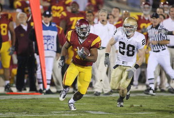 LOS ANGELES - NOVEMBER 29:  Stafon Johnson #13 of the USC Trojans carries the ball against Kyle McCarthy #28 of the Notre Dame Fighting Irish on November 29, 2008 at the Los Angeles Memorial Coliseum in Los Angeles, California.  USC won 38-3.  (Photo by Jeff Golden/Getty Images)