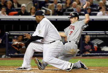 NEW YORK - OCTOBER 07:  Joe Mauer #7 of the Minnesota Twins slides into home safely past CC Sabathia #52 of the New York Yankees on a passed ball by Jorge Posada #20 in the third inning of Game One of the ALDS during the 2009 MLB Playoffs at Yankee Stadium on October 7, 2009 in the Bronx borough of New York City.  (Photo by Jim McIsaac/Getty Images)