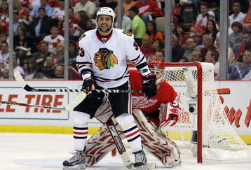 DETROIT - MAY 19:  Dustin Byfuglien #33 of the Chicago Blackhawks sets up on offense in front of goalie Chris Osgood #30 of the Detroit Red Wings during Game Two of the Western Conference Championship Round of the 2009 Stanley Cup Playoffs on May 19, 2009 at Joe Louis Arena in Detroit, Michigan. The Red Wings won 3-2 in overtime. (Photo by Dave Sandford/Getty Images)