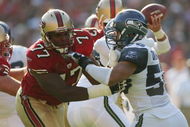 SAN FRANCISCO - NOVEMBER 7:  Offensive tackle Kwame Harris #77 of the San Francisco 49ers tries to hold a block against defensive end Chike Okeafor #50 of the Seattle Seahawks at Monster Park on November 7, 2004 in San Francisco, California. The Seahawks defeated the 49ers 42-27. (Photo by Jed Jacobsohn/Getty Images)