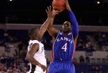 INDIANAPOLIS - MARCH 27:  Sherron Collins #4 of the Kansas Jayhawks attempts a shot against Travis Walton the Michigan State Spartans during the third round of the NCAA Division I Men's Basketball Tournament at the Lucas Oil Stadium on March 27, 2009 in Indianapolis, Indiana.  (Photo by Andy Lyons/Getty Images)