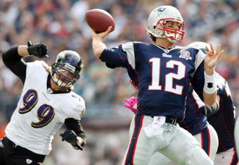FOXBORO, MA - OCTOBER 04: Tom Brady #12 of the New England Patriots passes the ball under pressure by Paul Kruger #99 of the Baltimore Ravens on October 4, 2009 at Gillette Stadium in Foxboro, Massachusetts. The Patriots defeated the Ravens 27-21.  (Photo by Elsa/Getty Images)