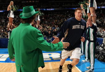 DENVER - MARCH 20:  Luke Harangody #44 of the Notre Dame Fighting Irish is greeted by the team mastcot during introductions to the first round game of the East Regional against the George Mason Patriots as part of the 2008 NCAA Men's Basketball Tournament at Pepsi Center on March 20, 2008 in Denver, Colorado. The Fighting Irish defeated the Patriots 68-50.  (Photo by Doug Pensinger/Getty Images)