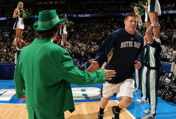 DENVER - MARCH 20:  Luke Harangody #44 of the Notre Dame Fighting Irish is greeted by the team mastcot during introductions to the first round game of the East Regional against the George Mason Patriots as part of the 2008 NCAA Men's Basketball Tournament at Pepsi Center on March 20, 2008 in Denver, Colorado. The Fighting Irish defeated the Patriots 68-50.  (Photo by Doug Pensinger/Getty Images)
