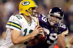MINNEAPOLIS - OCTOBER 05:  Quarterback Aaron Rodgers #12 of the Green Bay Packers is chased by Jared Allen #69 of the Minnesota Vikings during the Monday Night Football game on October 5, 2009 at Hubert H. Humphrey Metrodome in Minneapolis, Minnesota.  (Photo by Jamie Squire/Getty Images)