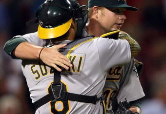 BOSTON - JULY 06:  Starting pitcher Brett Anderson #49 of the Oakland Athletics is congratulated by Kurt Suzuki #8 after his shutout against the Boston Red Sox on July 6, 2009 at Fenway Park in Boston, Massachusetts. The Athletics defeated the Red Sox 6-0.  (Photo by Elsa/Getty Images)