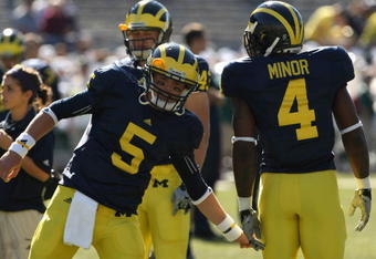 ANN ARBOR, MI - SEPTEMBER 19:  Quarterback Tate Forcier #5 of the Michigan Wolverines greets running back Brandon Minor #4 during warmups for the game against the Eastern Michigan Eagles at Michigan Stadium on September 19, 2009 in Ann Arbor, Michigan.  Michigan won 45-17.  (Photo by Stephen Dunn/Getty Images)