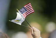 UNITED STATES - SEPTEMBER 22:  A fan waves U.S. and Presidents Cup flags during the opening ceremony of The Presidents Cup at Robert Trent Jones Golf Club in Prince William County, Virginia on September 22, 2005.  (Photo by Hunter Martin/Getty Images)