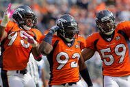DENVER - OCTOBER 04:  Elivs Dumervil #92 of the Denver Broncos celebrates his sack of quarterback Tony Romo #9 of the Dallas Cowboys with teammates Darrell Reid #95 and Wesley Woodyard #59 during NFL action at Invesco Field at Mile High on October 4, 2009 in Denver, Colorado. The Broncos defeated the Cowboys 17-10.  (Photo by Doug Pensinger/Getty Images)