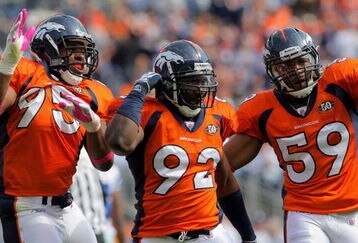 DENVER - OCTOBER 04:  Elivs Dumervil #92 of the Denver Broncos celebrates his sack of quarterback Tony Romo #9 of the Dallas Cowboys with teammates Darrell Reid #95 and Wesley Woodyard #59 during NFL action at Invesco Field at Mile High on October 4, 2009 in Denver, Colorado. The Broncos defeated the Cowboys 17-10.  (Photo by Doug Pensinger/Getty Images)